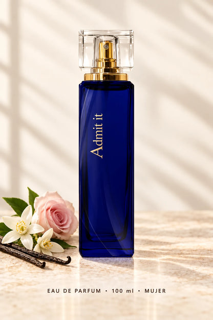 Admit It Eau de Parfum de 100 ml para mujer, frasco azul sobre fondo claro con flores y vainilla.
